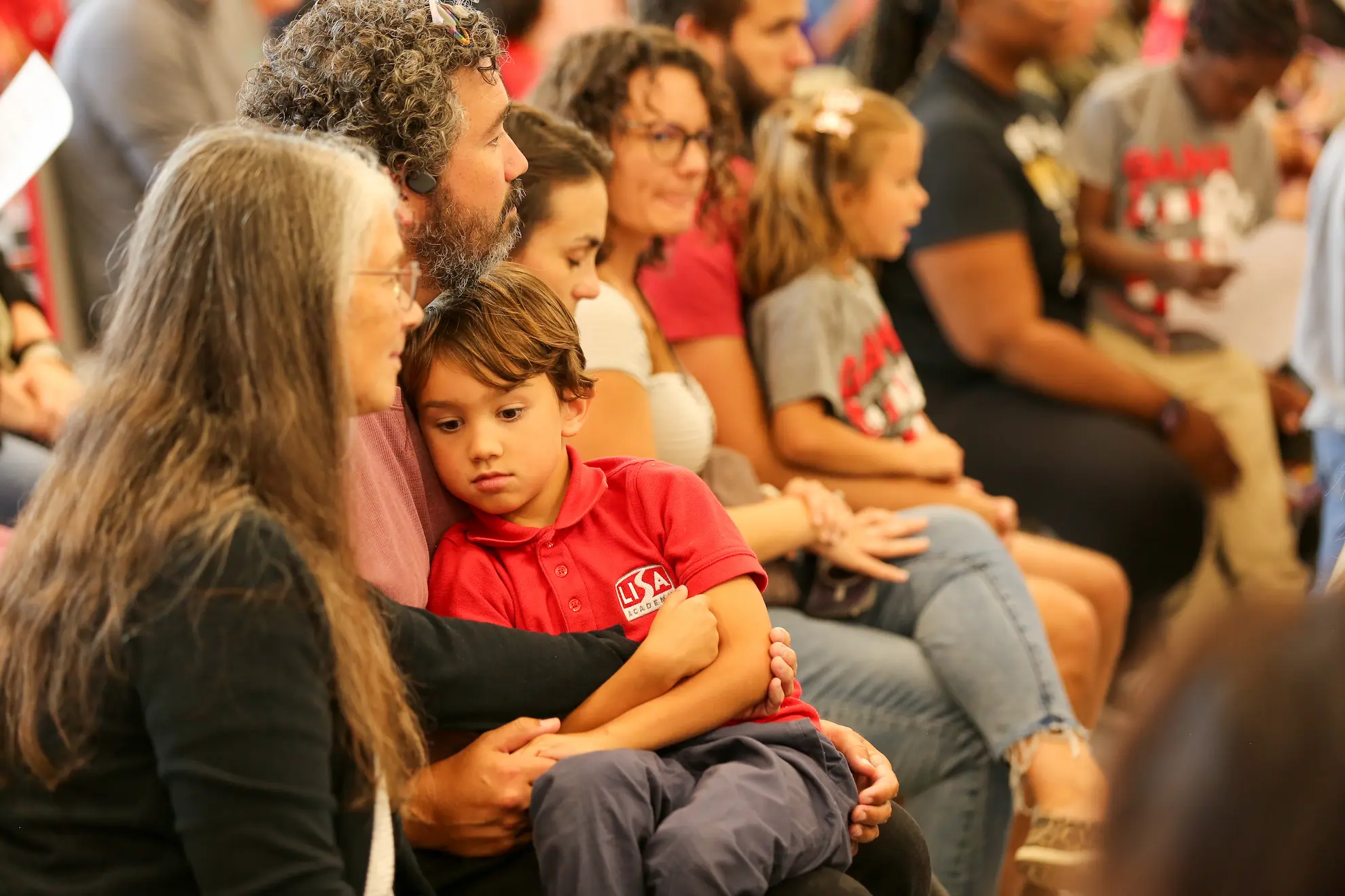 A LISA Academy family listening together at a school event